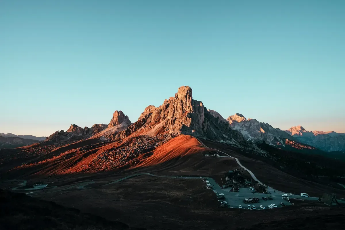 Mountain peak lit orange by the low sun, cover image for AI and the risks of slow ownership
